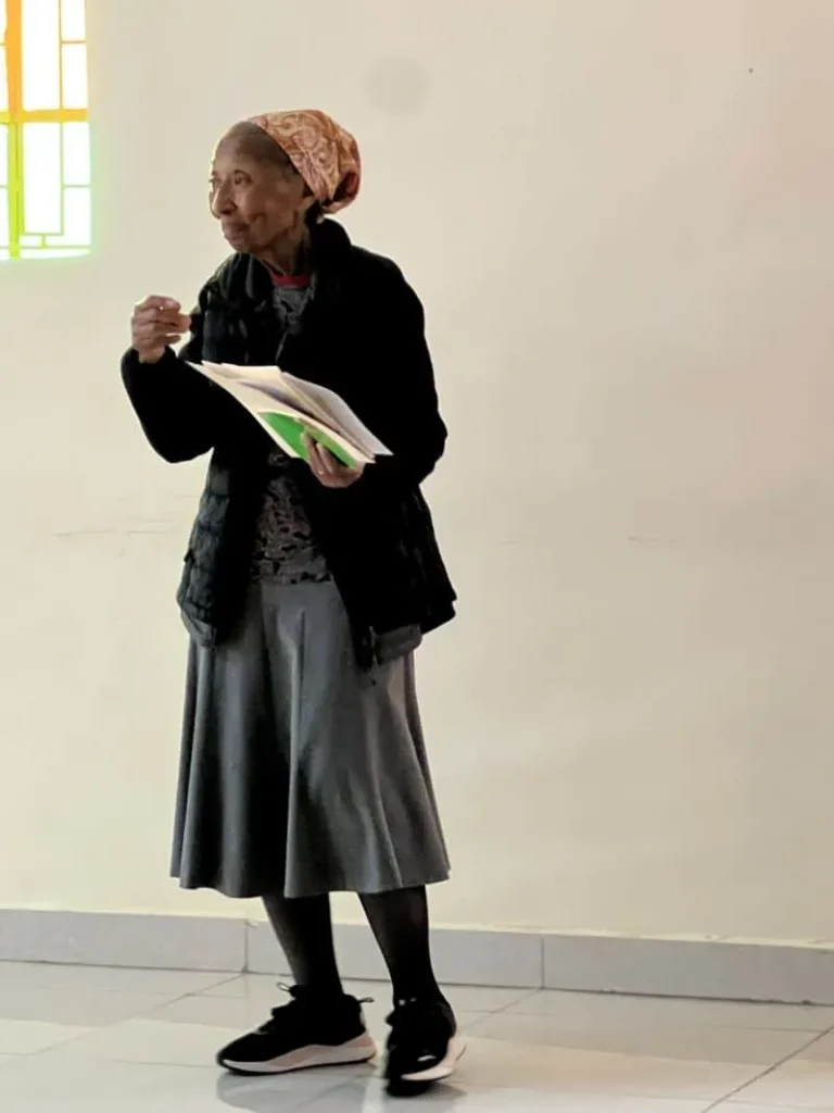 Sr. Barbara standing alone with papers in her hand as if she is talking to a group