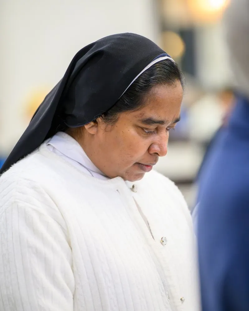 Sister in a veil with head down thinking reflectively