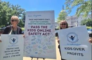 NAC partners Fran and Meg hold up signs at an advocacy event in Washington, D.C. 