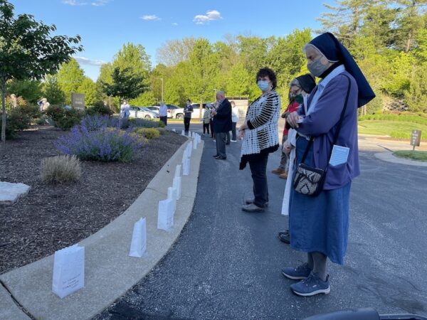 Sisters stand by luminaries as names of deceased are called