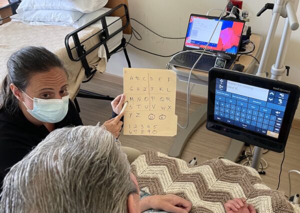 speech therapist using alphabet card with patient